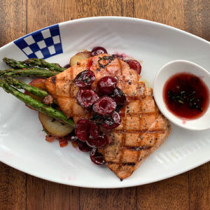Grilled salmon fillet with cherries, asparagus, and potatoes