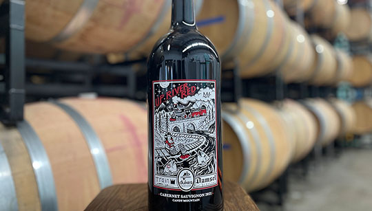 Up River Red Wine Bottle Bottle of Up River Red from Duke's Damsel on a Train with oak barrels in the background